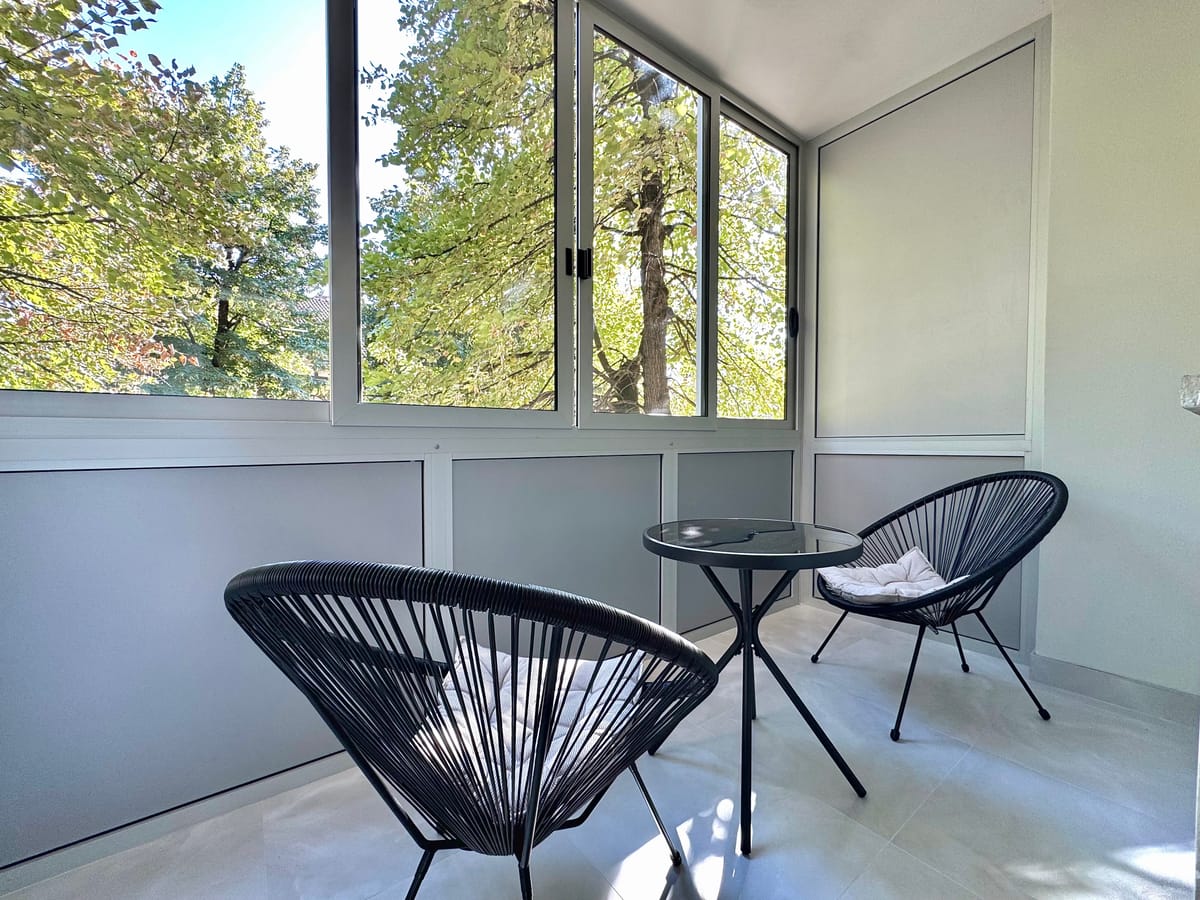 Balkon mit zwei Stühlen und kleinem Tisch